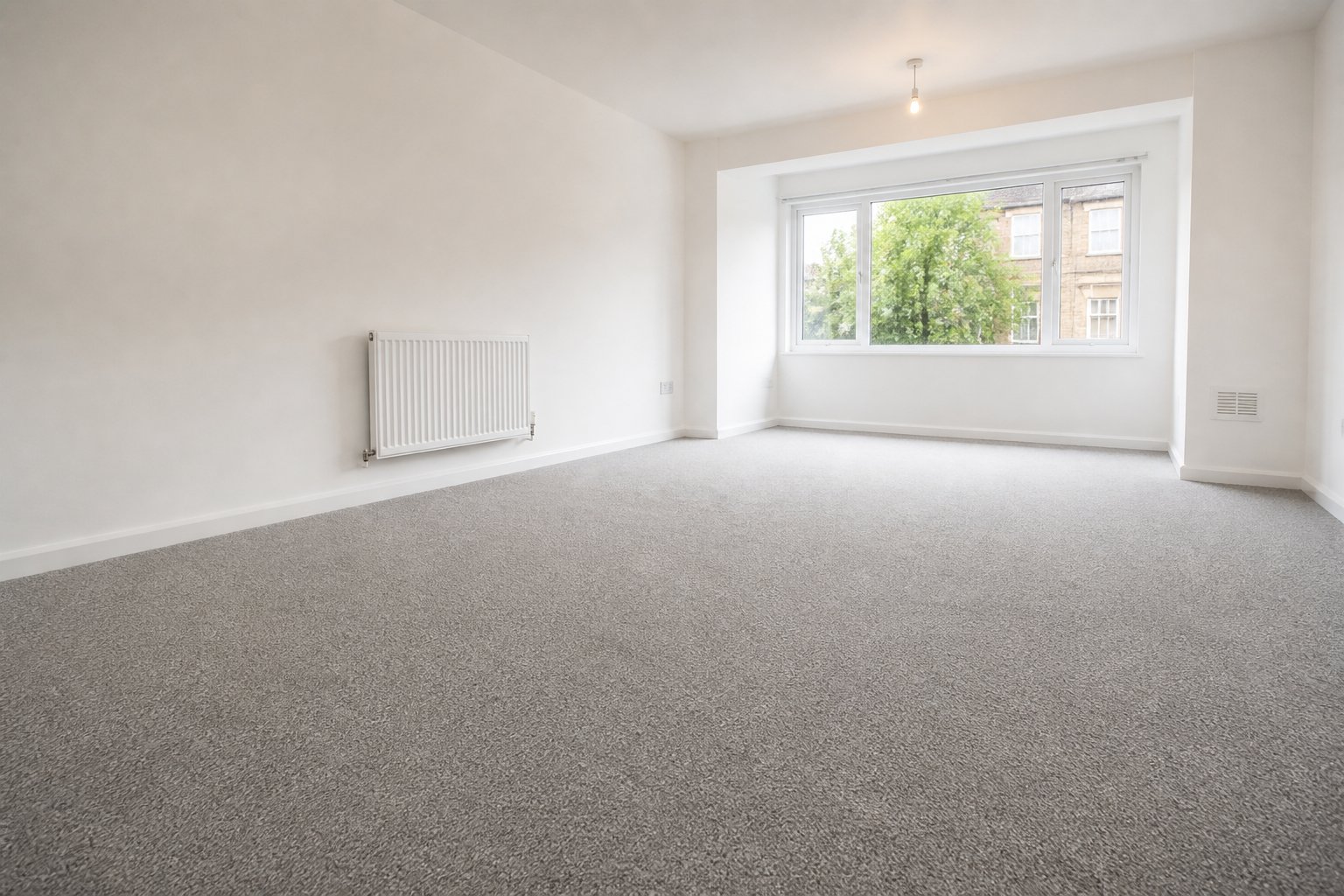 Freshly prepared rental living room with durable fitted carpet