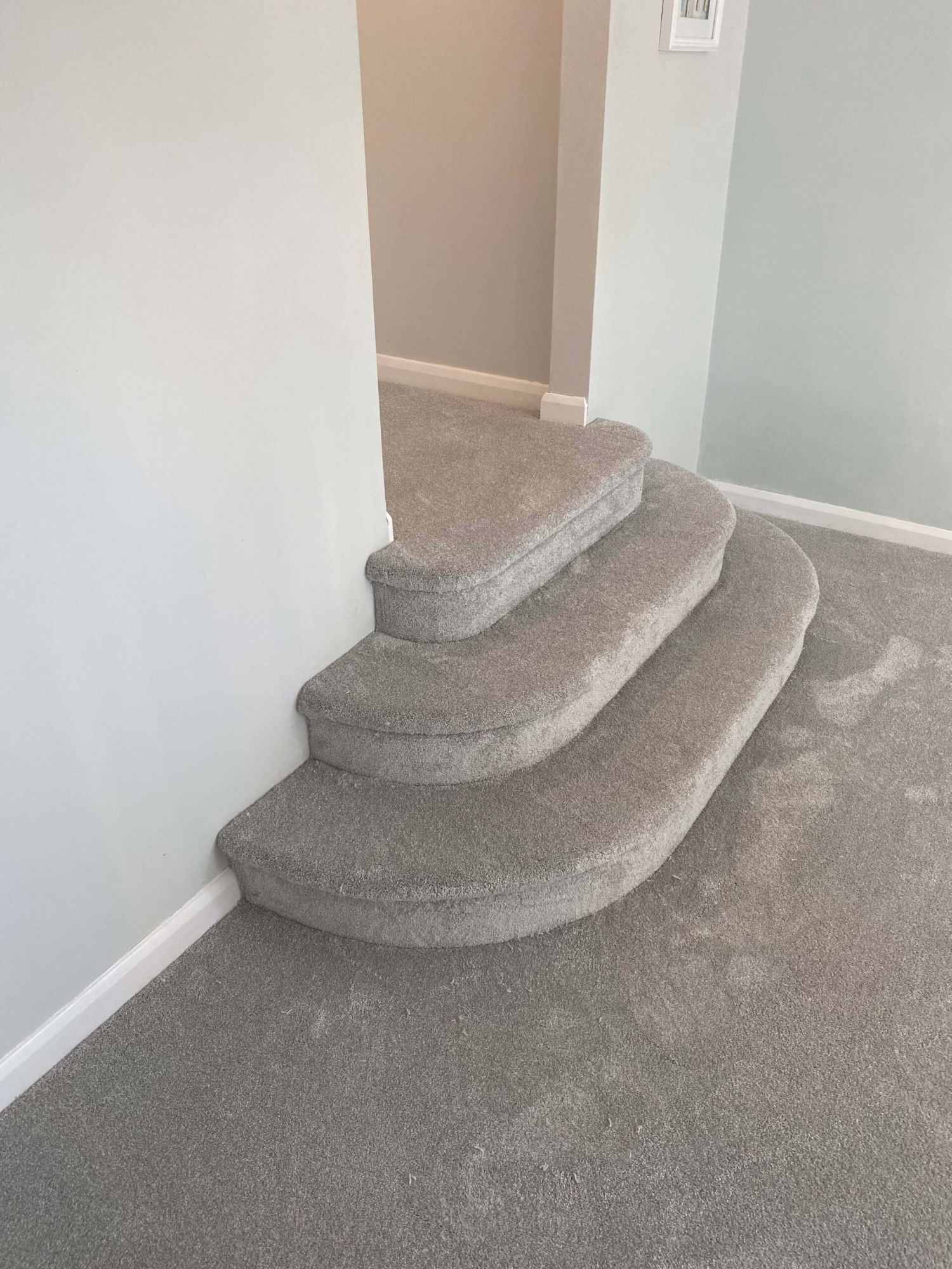 Grey carpet fitted around curved bullnose steps